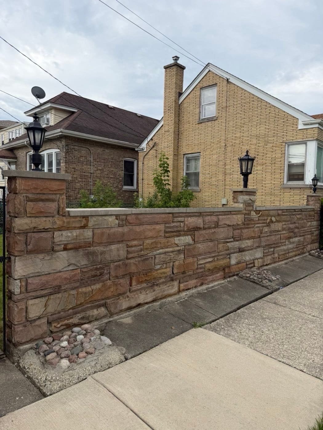 Stone wall and walkway cleaned along a brick home
